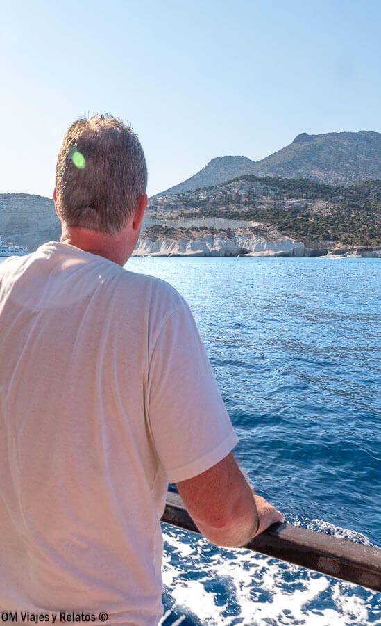Foto de JC en barco contemplando la costa y acantilados de Milos, ruta ideal para descubrir las mejores playas de Milos.