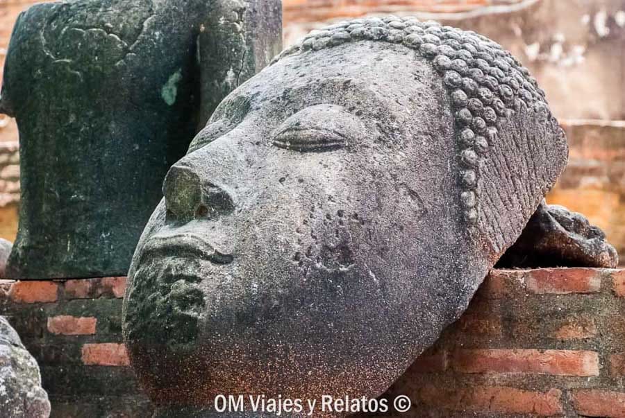 Rostro erosionado de estatua de Buda decapitada en las ruinas de Ayutthaya en un día de excursión