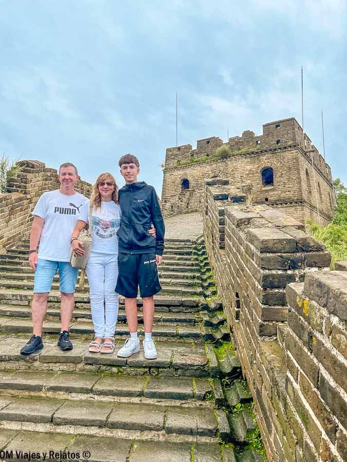 Foto familiar de OM Viajes y Relatos posando en las escaleras de la Gran Muralla China cerca de Pekín, excursión imprescindible en que ver en Pekín en 4 días.