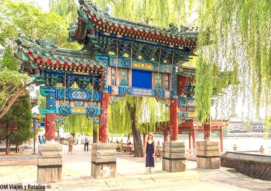 Foto de una servidora en el Parque Beihai, bajo un arco tradicional chino, una visita relajante en que ver en Pekin en 4 días.