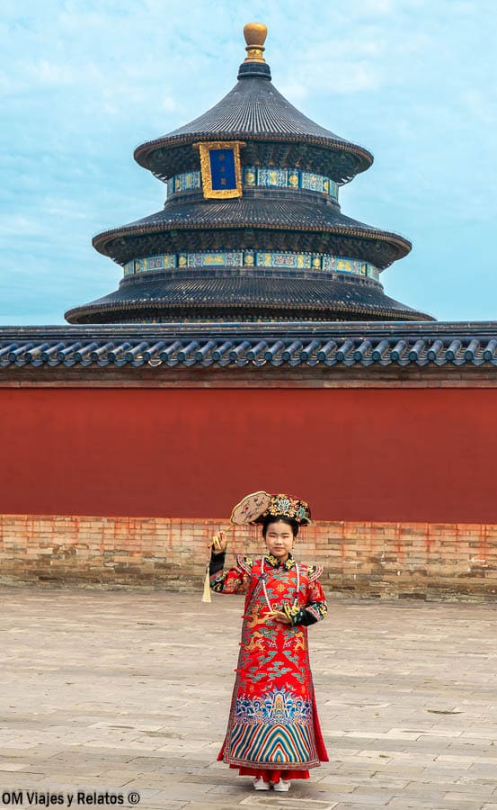 Mujer con vestido tradicional chino frente al Salón de Oración del Templo del Cielo, una foto típica al visitar el Templo del Cielo de Pekín.