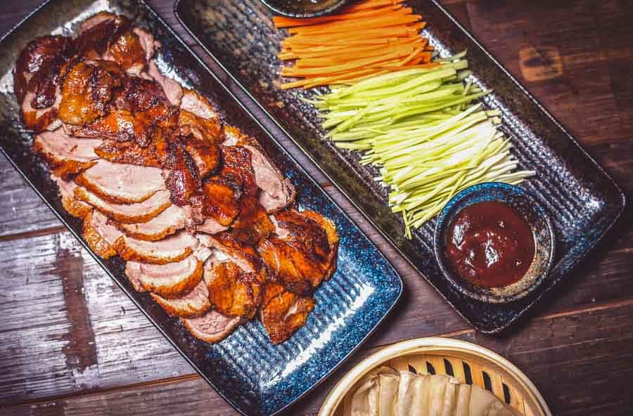 Pato laqueado de Pekín servido con salsa y verduras para envolver, plan gastronómico top en que ver en Pekin en 4 días.