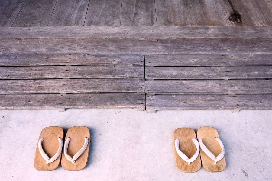 Sandalias geta en la entrada de un ryokan tradicional, experiencia típica de aguas termales en Japón.
