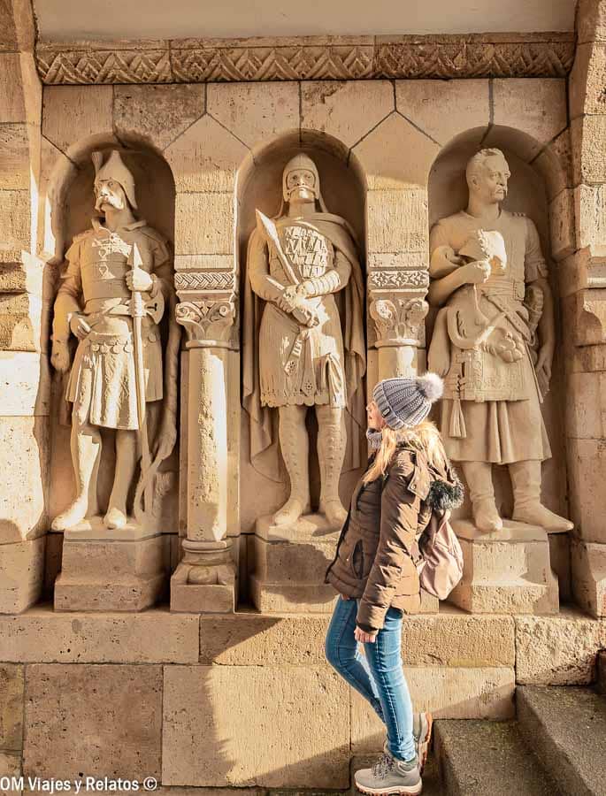 Foto mía paseando junto a estatuas de piedra en el recinto, un rincón curioso de que ver en el Castillo de Buda.