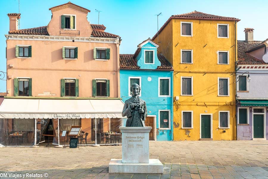 Plaza Baldassare Galuppi en Burano con casas de colores y estatua central, un imprescindible en que ver en Burano.
