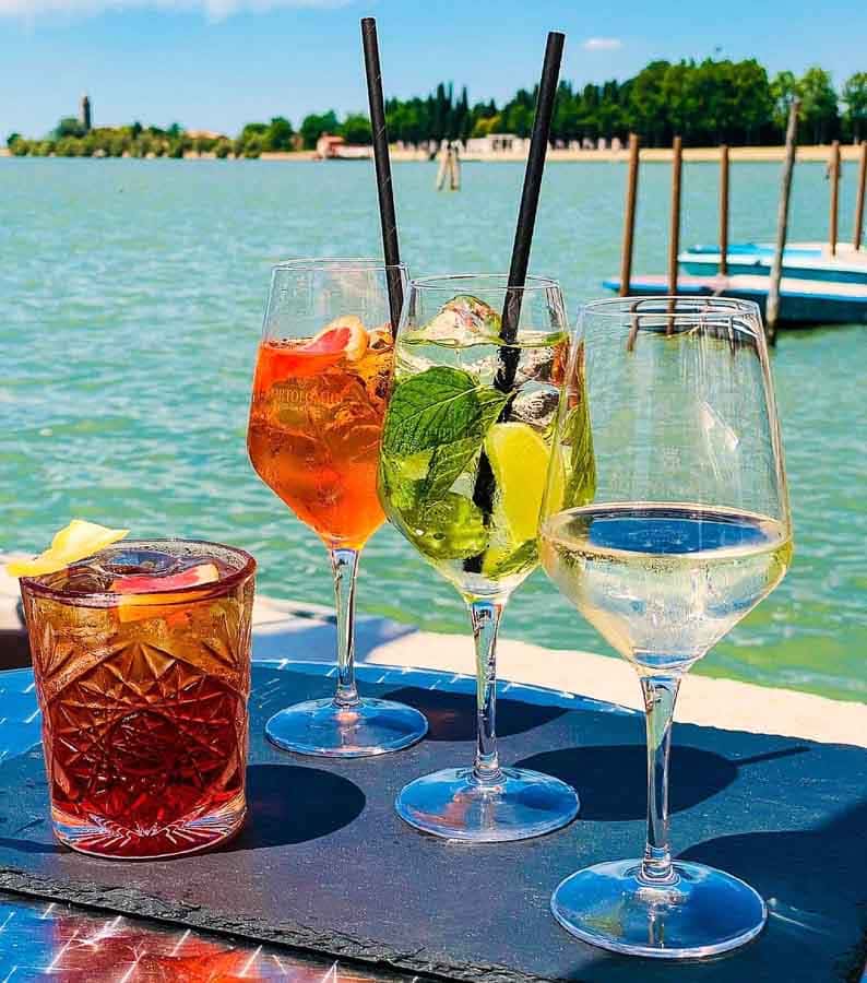 Aperitivo con cócteles junto a la laguna de Venecia, una parada deliciosa para completar que ver en Burano.
