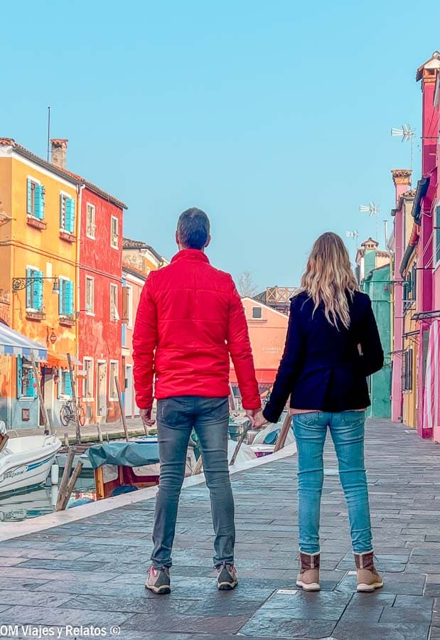 JC y Olga caminando por el canal entre casas de colores en Burano, una escena clave sobre que ver en Burano.