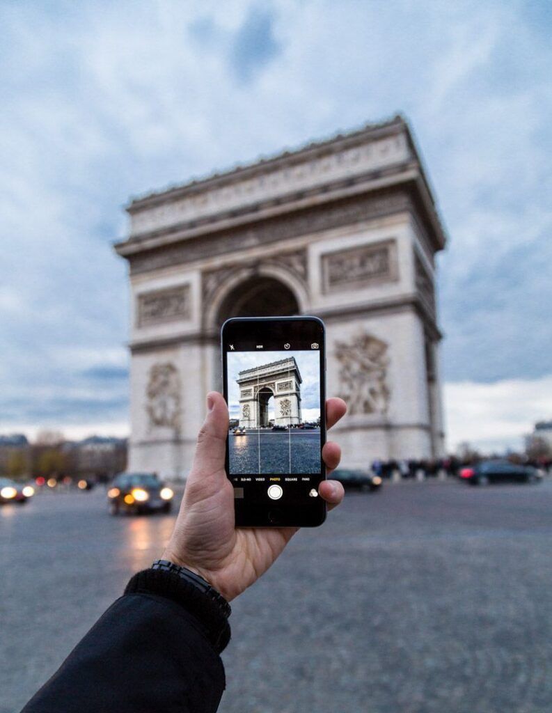 Foto mía sosteniendo un móvil que fotografía el Arco del Triunfo en Paris en 3 días.