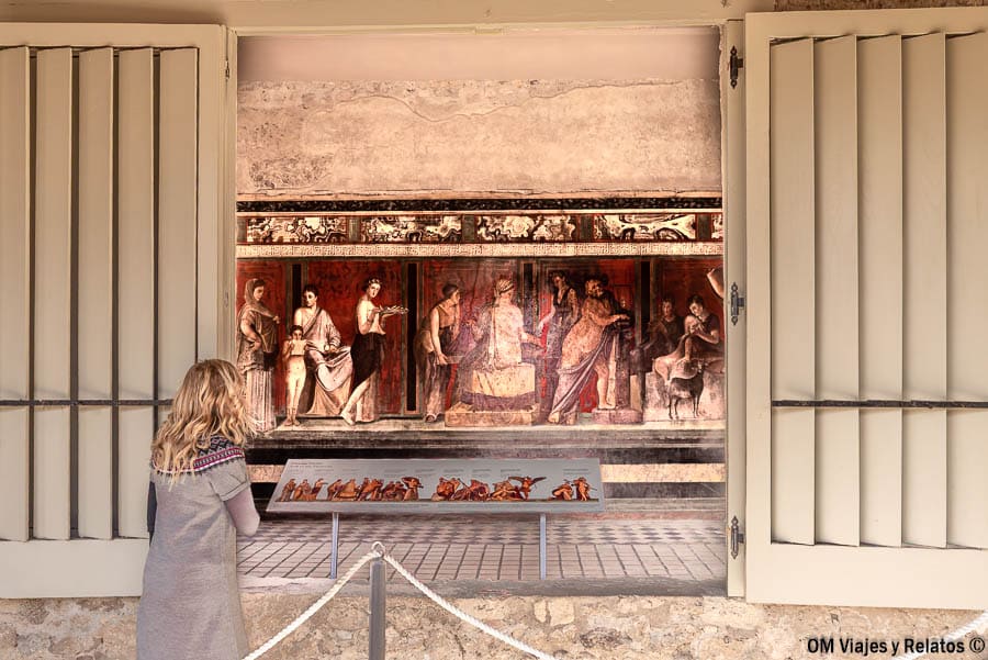 Foto mía observando los frescos de la Villa de los Misterios en Pompeya, una parada imprescindible al planificar como ir de Roma a Pompeya.