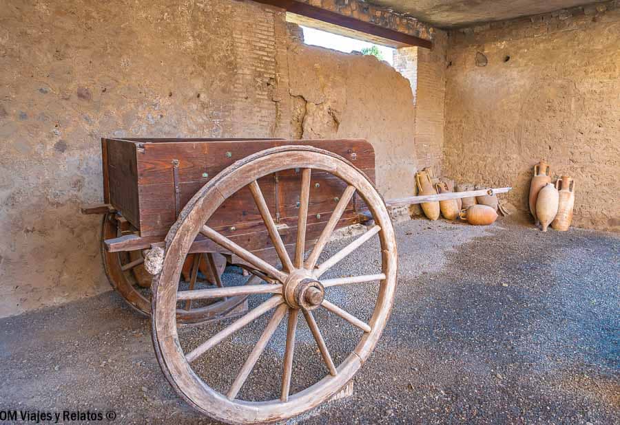 Carro antiguo de madera y ánforas en Pompeya, un detalle histórico fascinante al planificar como ir de Roma a Pompeya.