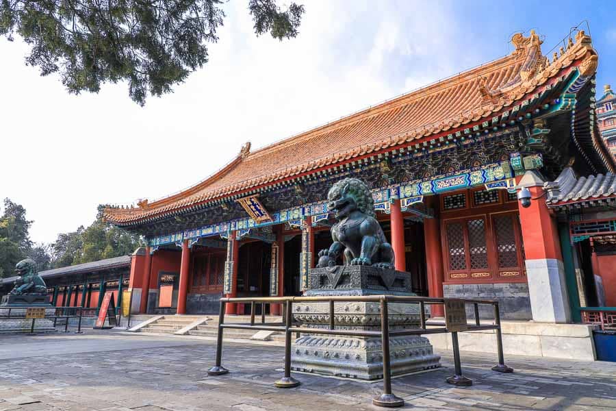 Entrada de templo tradicional en China con estatua de león guardián, una escena de viaje que acompaña consejos sobre como pagar en China.
