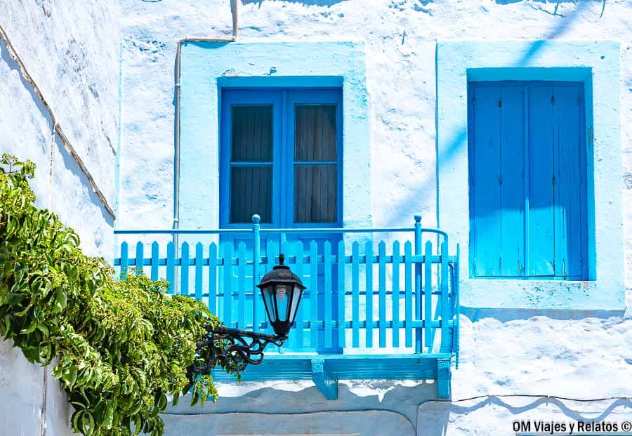 Casa tradicional blanca con balcón azul en Milos, una imagen típica para inspirar tu viaje y planificar como llegar a Milos.