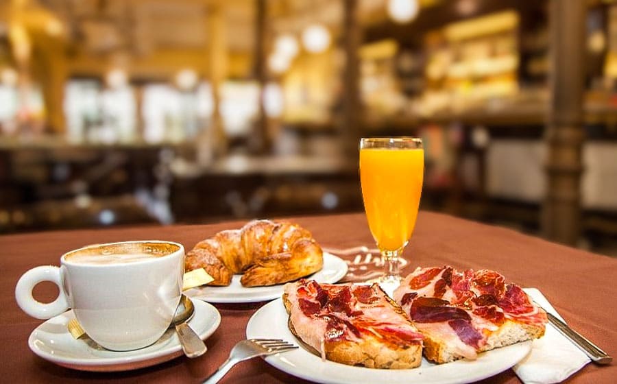 Desayuno típico con café, croissant, zumo y tostadas con jamón, un plan perfecto para recargar pilas en que ver en Salamanca en dos días.