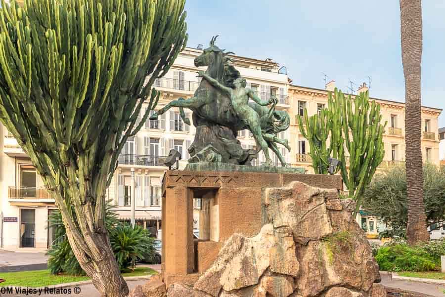 Escultura de bronce en un jardín de Cannes rodeada de cactus y palmeras, parada curiosa de que ver en Cannes.