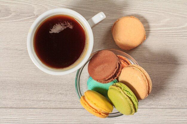 Macarons franceses de colores con taza de café, dulce típico que probar y ver en Cannes.