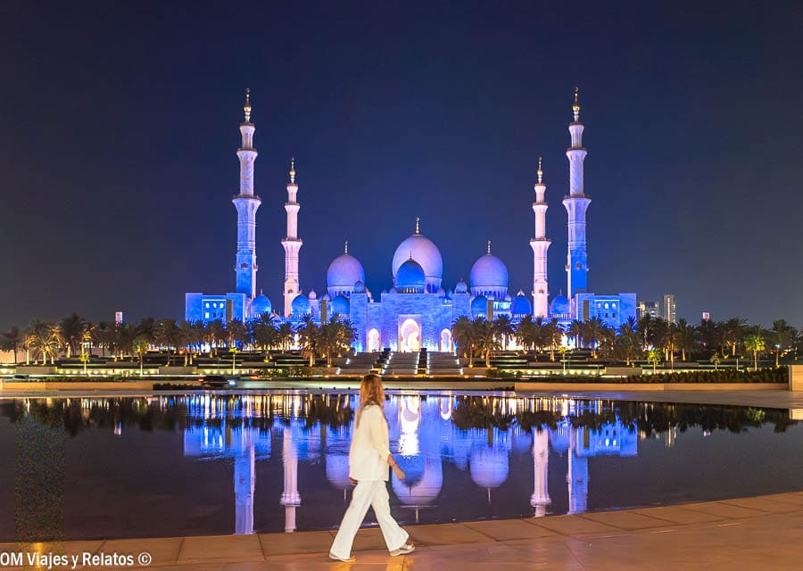 Una servidora en la Mezquita Sheikh Zayed iluminada de noche con reflejo en el agua, una excursión recomendable para incluir en los consejos para viajar a Dubai.