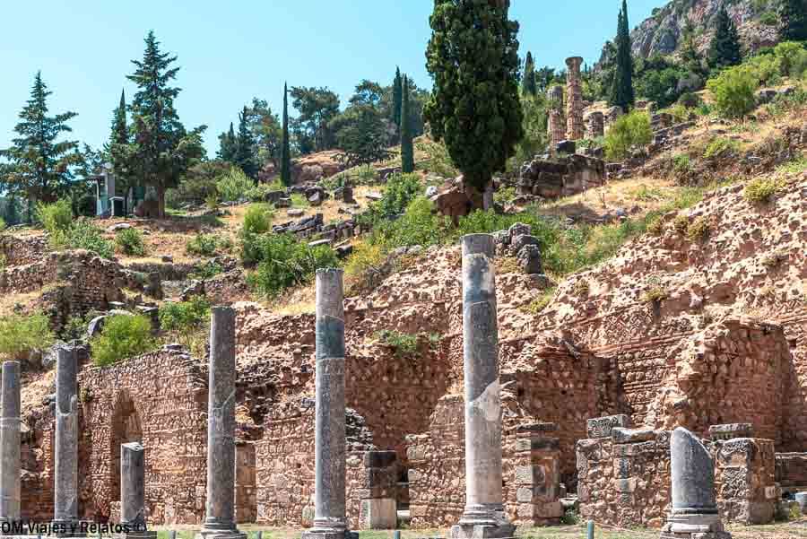 Ruinas y columnas del yacimiento arqueológico de Delfos en la ladera, imagen perfecta para visitar el Oráculo de Delfos.