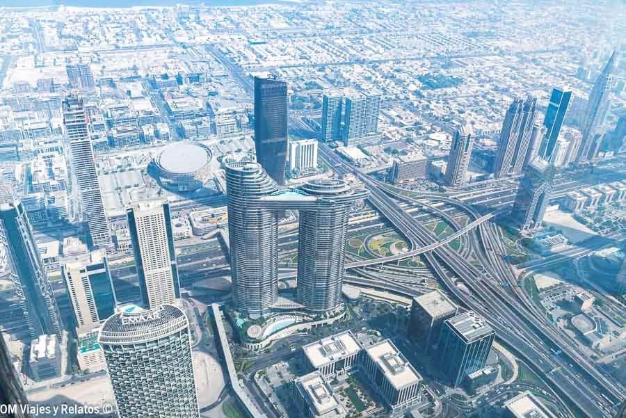 Subir al Burj Khalifa y contemplar las vistas panorámicas de Dubái desde lo más alto, con rascacielos y autopistas entrecruzadas a vista de pájaro.