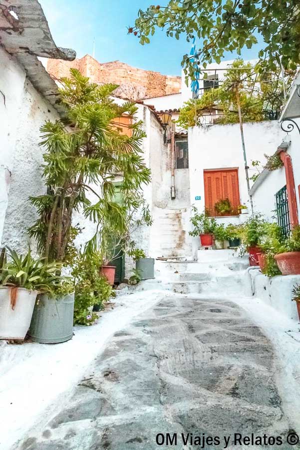 Callejuela blanca con plantas en el barrio de Plaka, uno de los rincones con más encanto que ver en Atenas en 2 días.