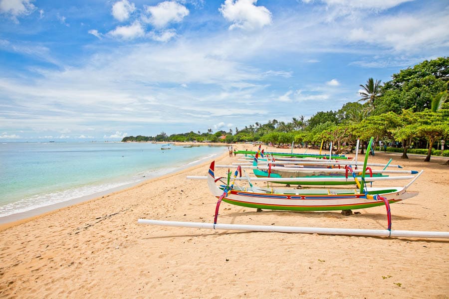 Barcas tradicionales en la playa de Bali junto al mar, imagen para un post sobre eSIM Bali y viajar conectado.