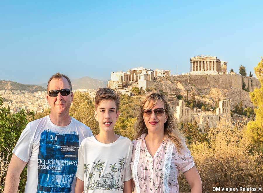 Foto familiar de OM Viajes y Relatos posando con vistas a la Acrópolis de Atenas y el Partenón, uno de los miradores imprescindibles que ver en Atenas en 2 dias.