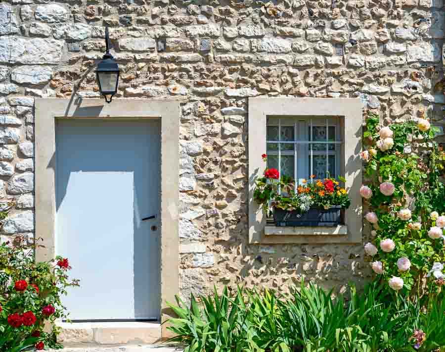 Casa de piedra con flores en Giverny, uno de los lugares con encanto que ver cerca de Paris.