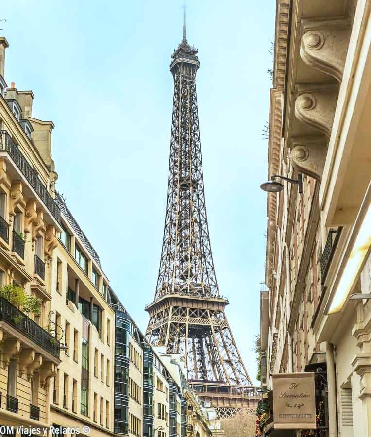 Torre Eiffel vista desde una calle de París, punto de partida ideal para descubrir que ver cerca de París.