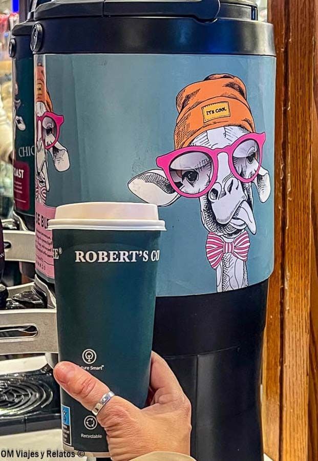 Una servidora tomando un café para llevar en una cafetería de diseño en la estación, parada práctica que ver en Helsinki en un día