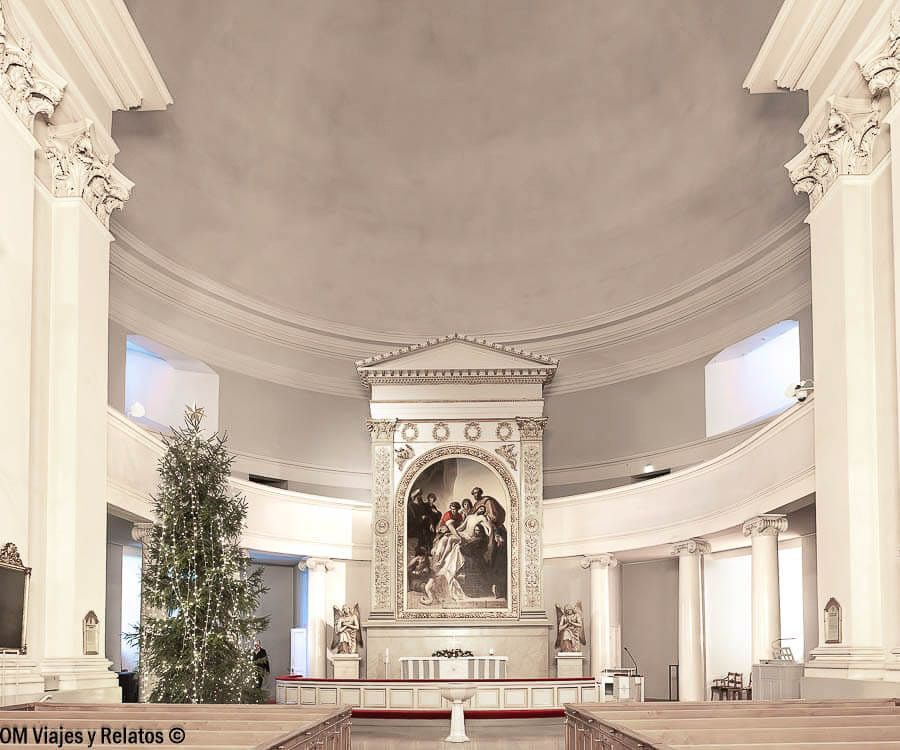 Altar principal de la Catedral luterana de Helsinki con gran pintura religiosa y columnas blancas, lugar destacado que ver en Helsinki en un día