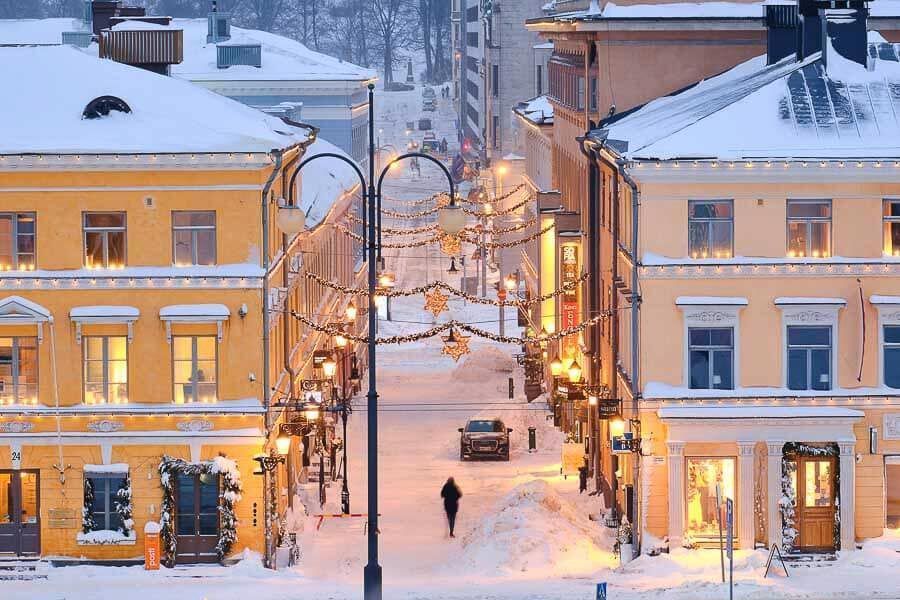 Fachadas históricas iluminadas y decoración navideña sobre la nieve, uno de los lugares más fotogénicos que ver en Helsinki en un día