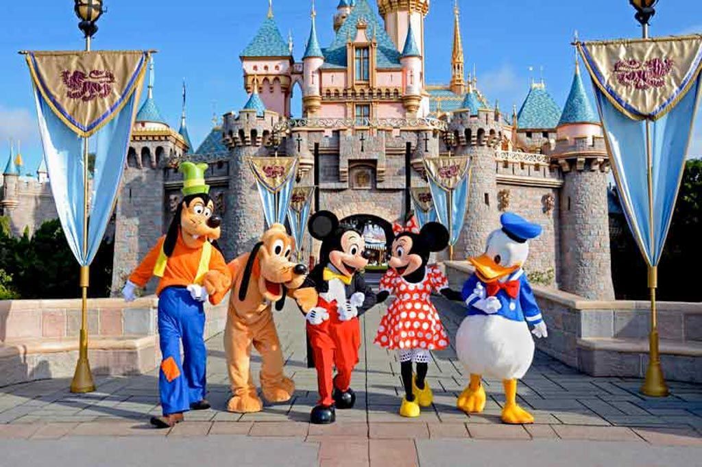 Personajes Disney frente al castillo de Disneyland, una excursión familiar que ver cerca de París.