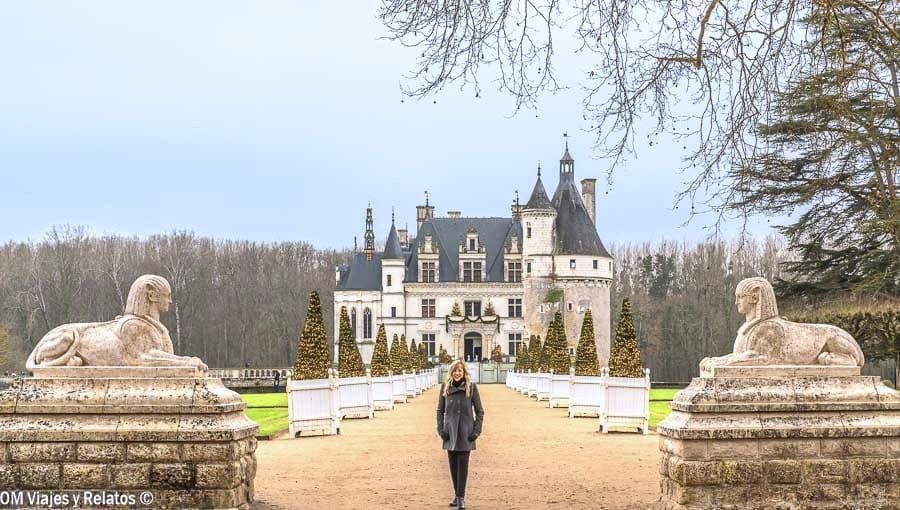 Foto mía frente al castillo de Chenonceau custodiado por esfinges, una de las visitas más espectaculares en una ruta por los castillos del Loira en coche.