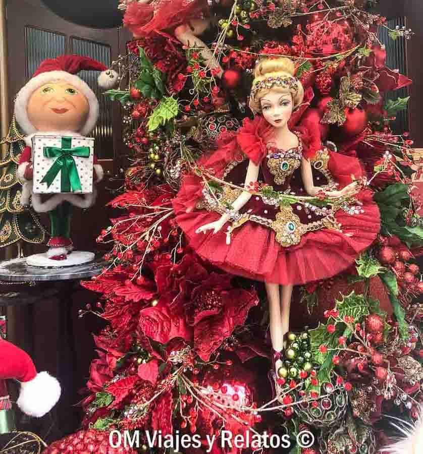 Decoración navideña en escaparate de Budapest con muñeca bailarina, árbol de Navidad y duende con regalo