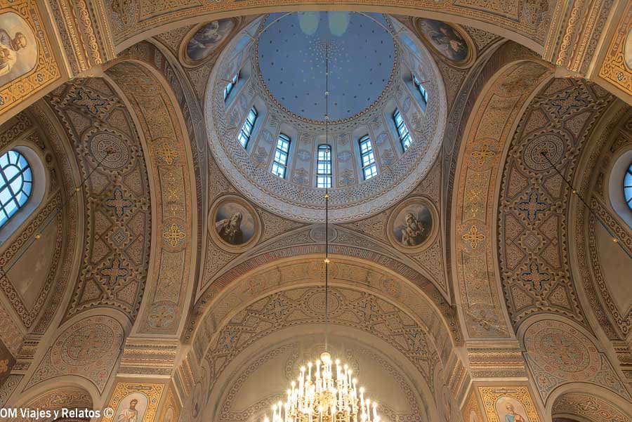 Techos ornamentados y ventanales de la catedral ortodoxa iluminados en Helsinki en Navidad
