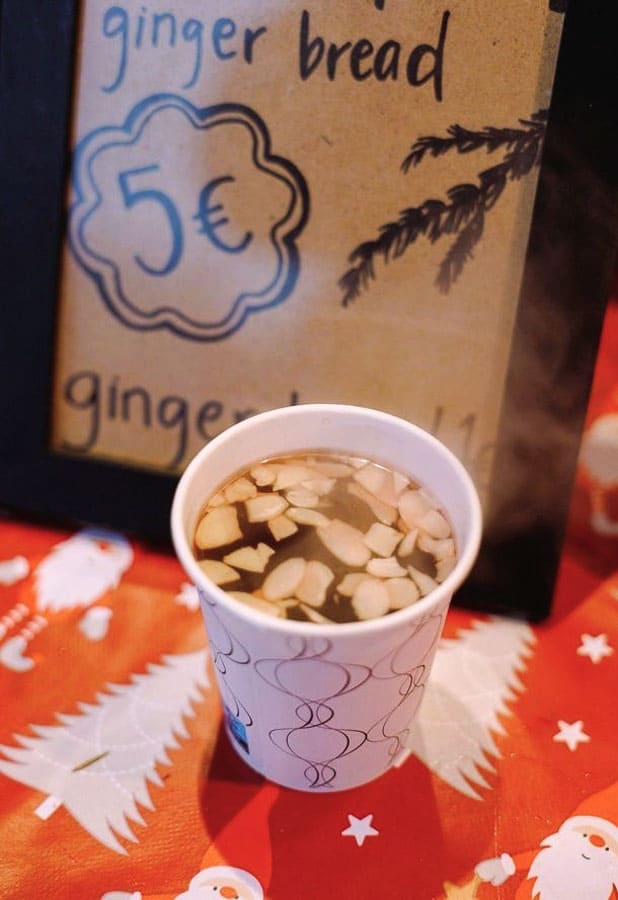 Vaso de glögi caliente con almendras en un puesto del mercado de Helsinki en Navidad