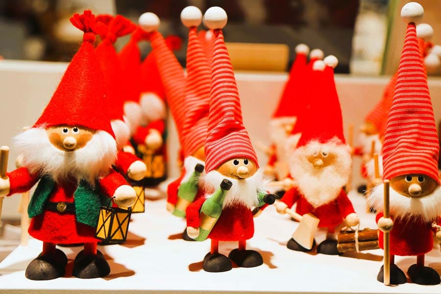 Pequeños elfos de madera decorando un puesto de mercado navideño en Helsinki en Navidad