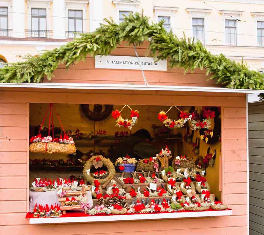 Caseta decorada con guirnaldas y figuras rojas típicas finlandesas en el mercado de Helsinki en Navidad