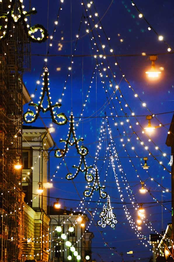 Decoración navideña de luces formando arcos sobre una avenida del centro de Helsinki en Navidad