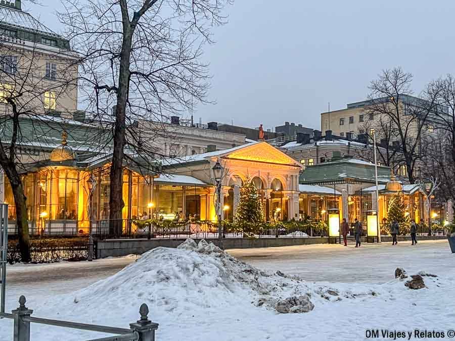Restaurante clásico con grandes ventanales dorados y decoración navideña en Helsinki en Navidad