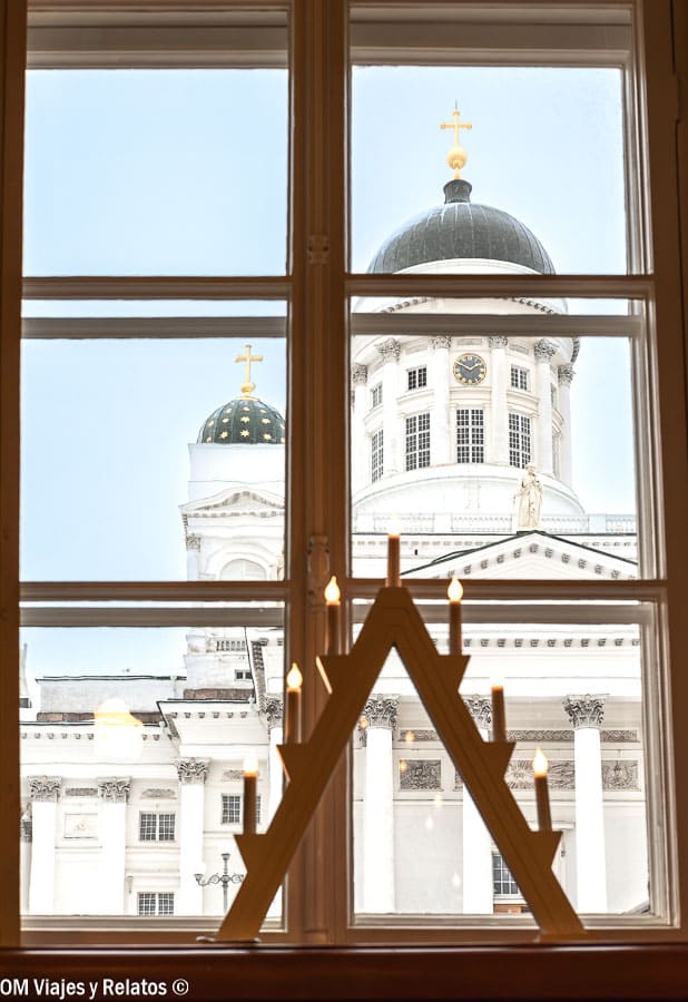 Decoración de velas navideñas en la ventana con la Catedral de Helsinki de fondo en Helsinki en Navidad