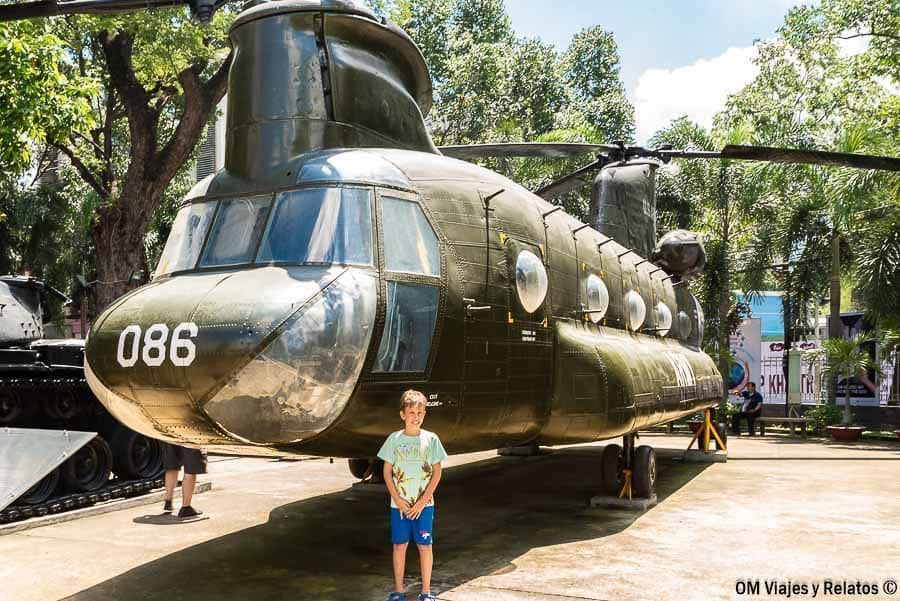 Mi hijo frente a un gran helicóptero de la guerra de Vietnam en museo al aire libre, uno de los imprescindibles en Vietnam.