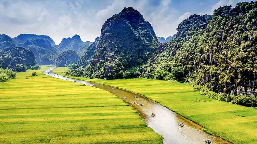 Paisaje de arrozales verdes y montañas de piedra caliza con río en Vietnam, parada natural imprescindible de Vietnam.