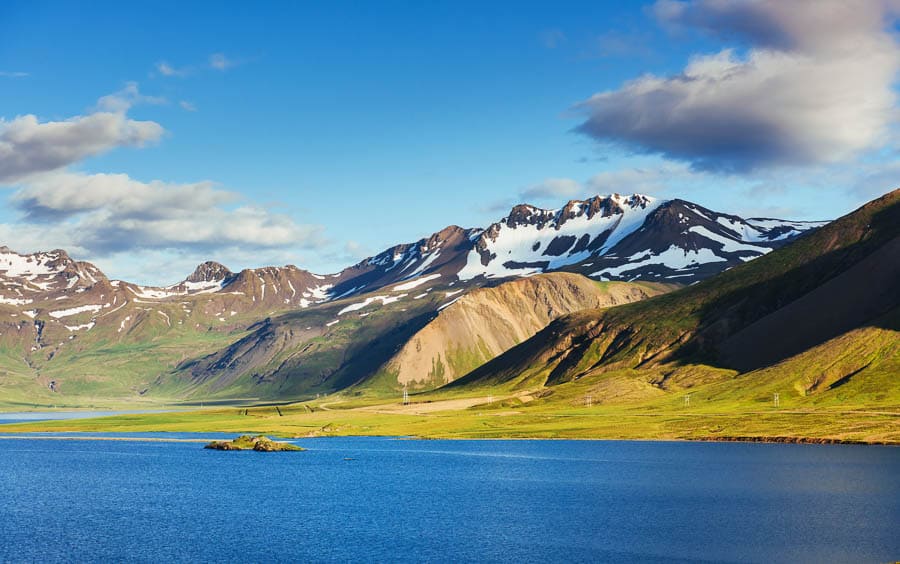 Vista panorámica de montañas y lago bajo cielo azul en Islandia en febrero