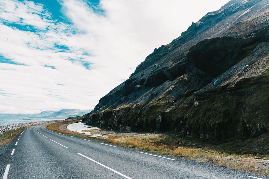 Paisaje de carretera panorámica junto a acantilados y océano en Islandia en febrero