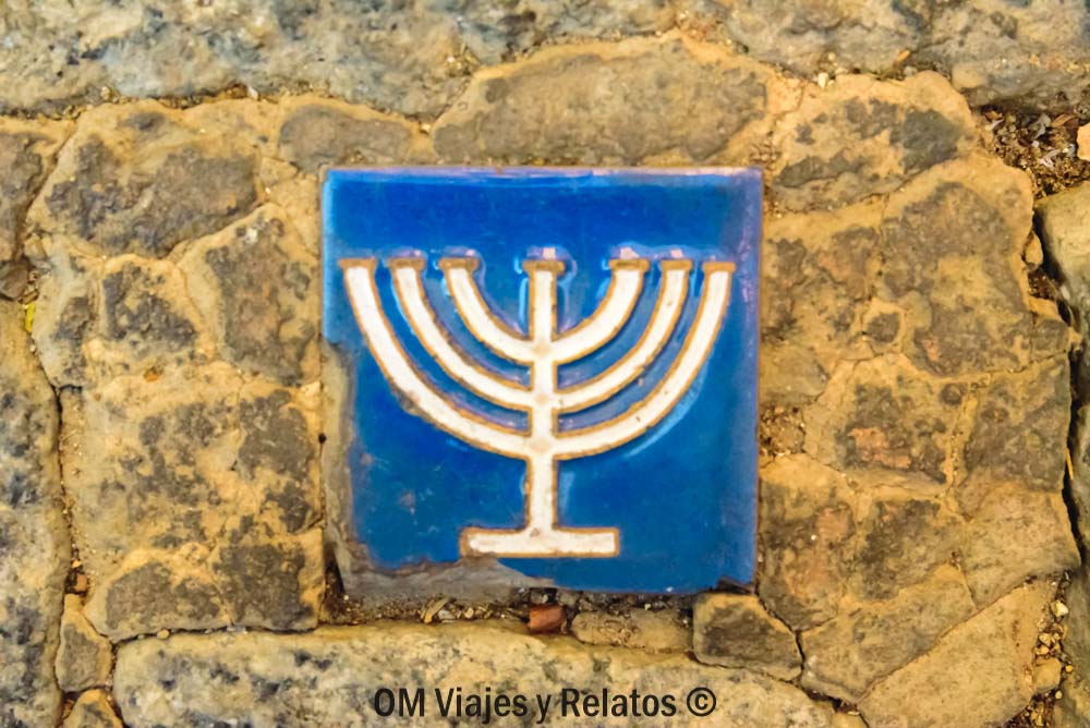 Detalle de azulejo azul con menorá en el suelo, símbolo del barrio judío en que ver en Toledo en un día