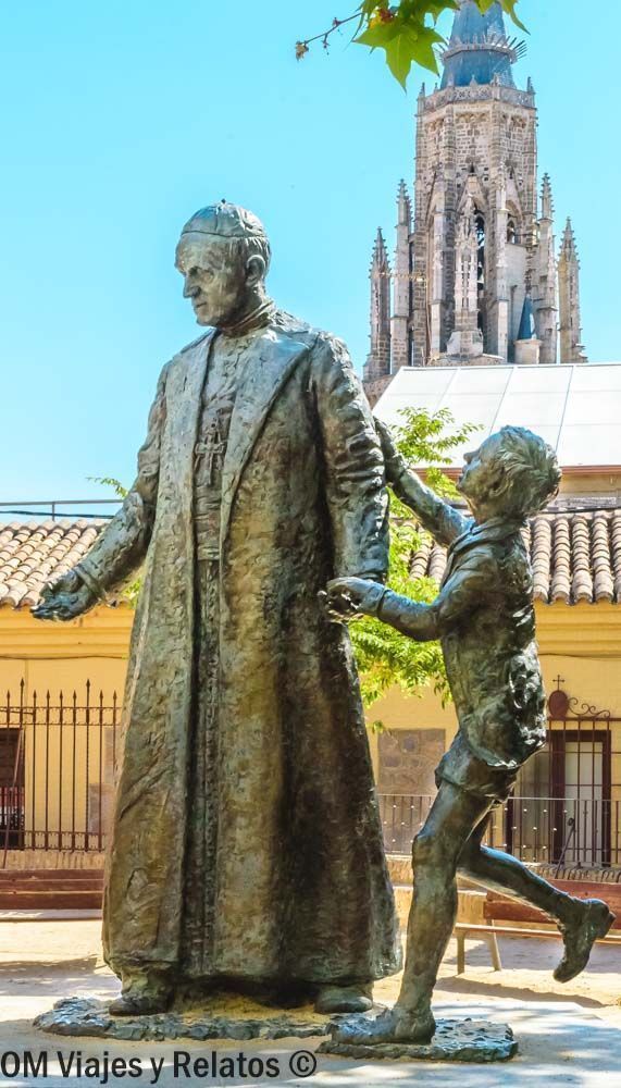 Que ver en Toledo en un día: monumento de bronce frente a la torre gótica de la Catedral de Toledo