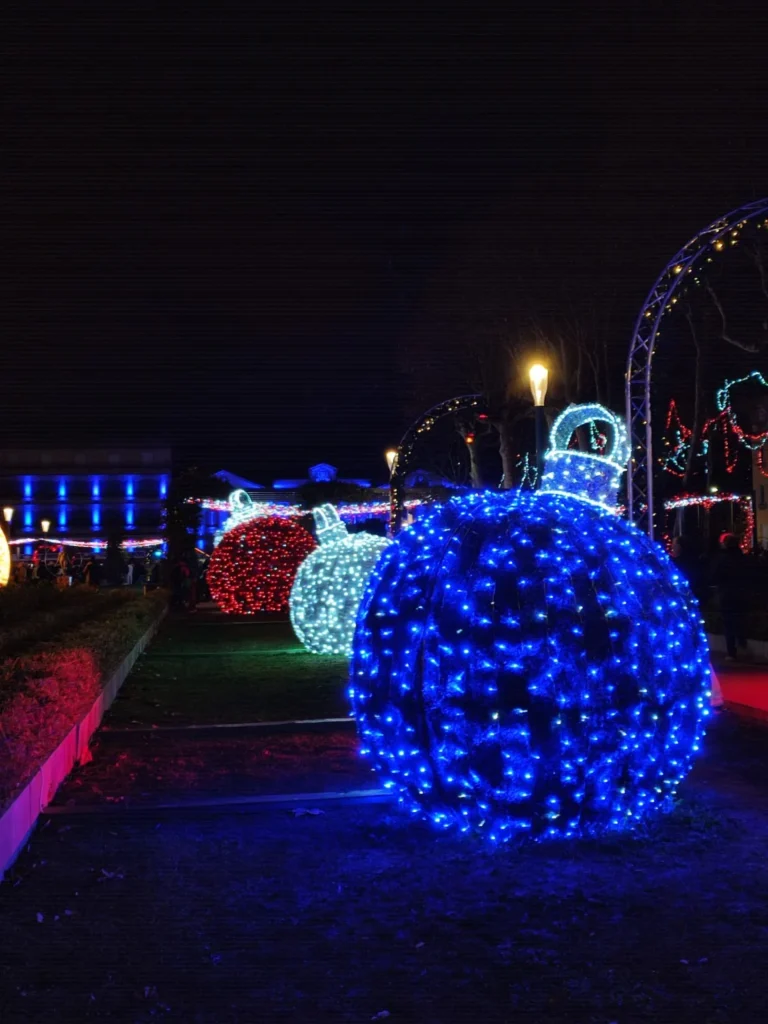 Bolas de Navidad gigantes iluminadas en un parque de Carcassonne en Navidad.