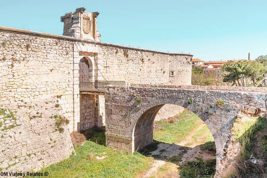 Vista del foso y la entrada de piedra al antiguo castillo de Chinchón, vestigio defensivo imprescindible en Chinchón que ver y donde comer