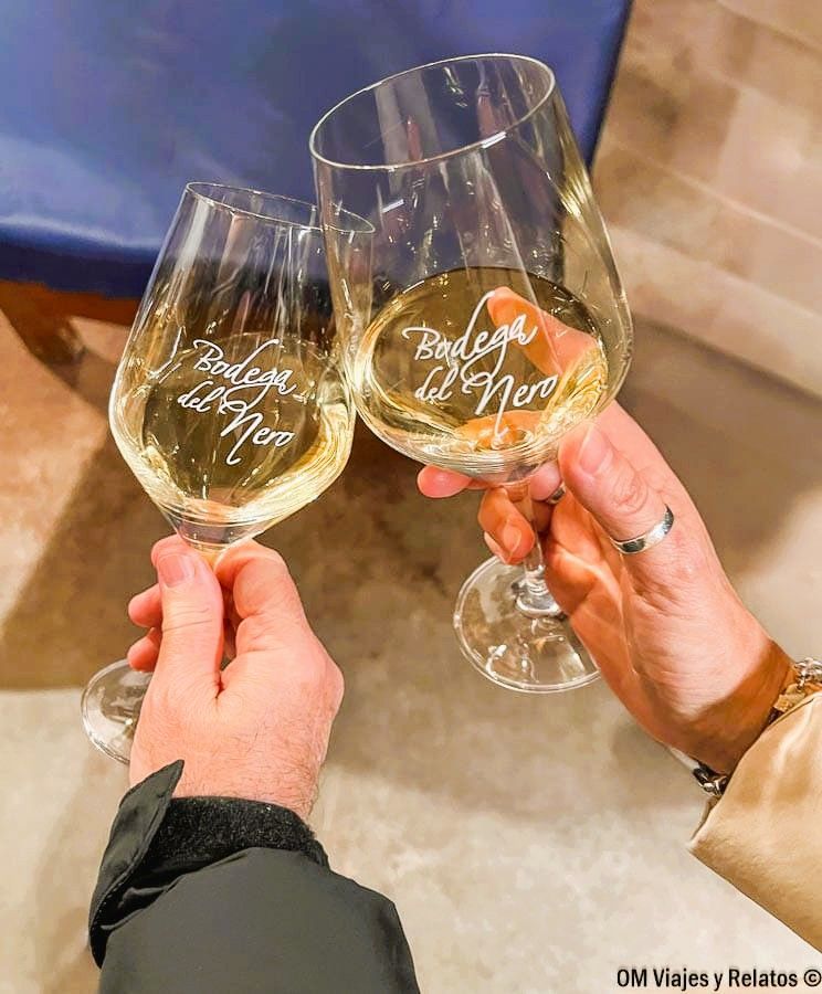 Brindis una servidora y JC con vino blanco en la Bodega del Nero, experiencia enológica en Chinchón que ver y donde comer