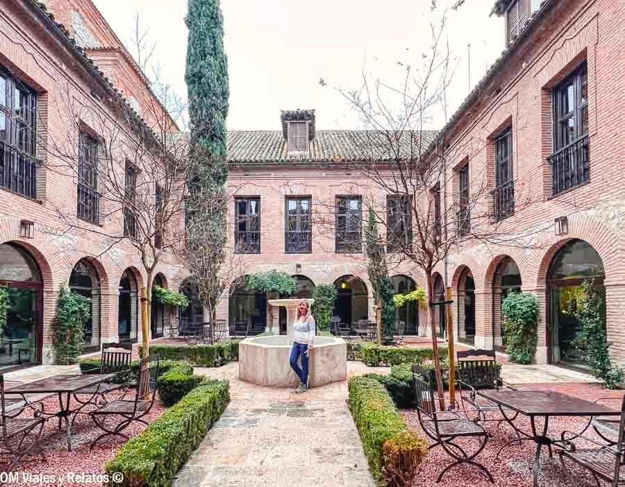 Yo junto a la fuente del claustro del Parador de Chinchón que ver y donde comer